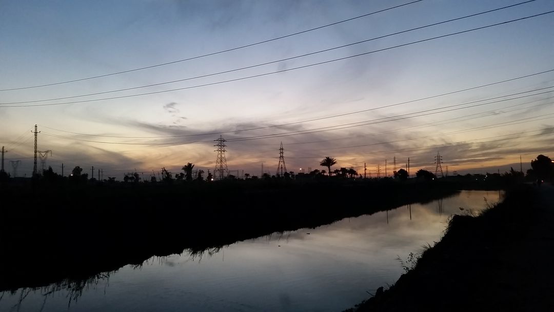 Scenic River Sunset with Silhouetted Power Lines - Free Images, Stock Photos and Pictures on Pikwizard.com