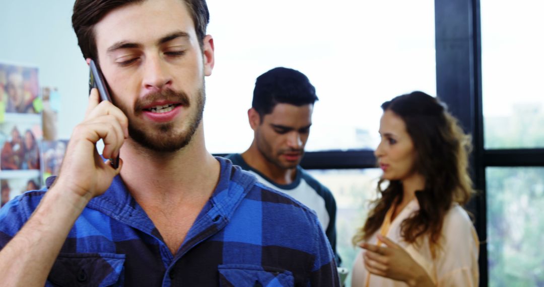 Creative Team Collaborating During Phone Call in Modern Office