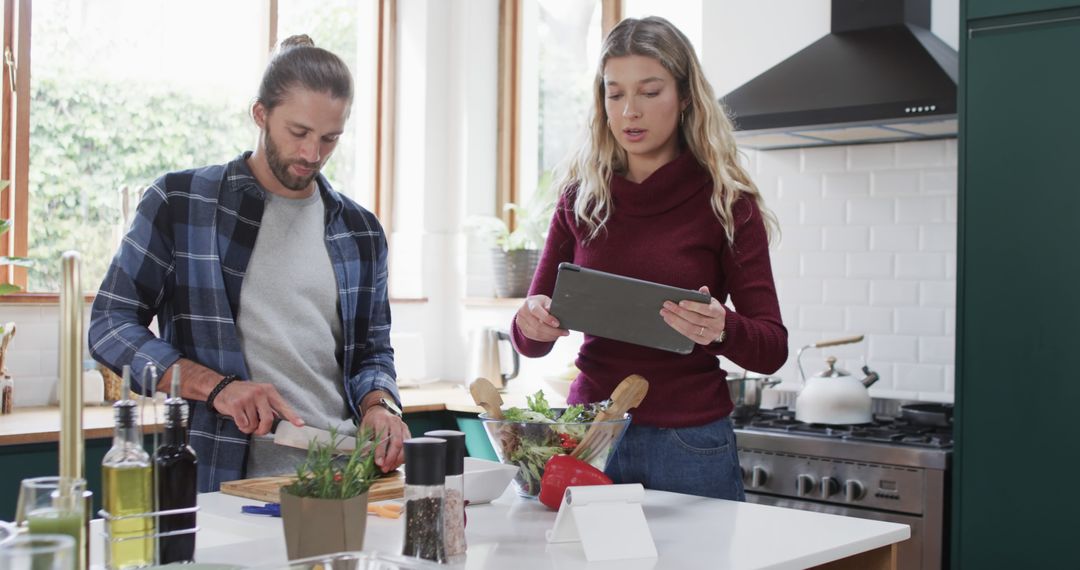 Couple Preparing Healthy Dinner Using Tablet for Recipe in Modern Kitchen