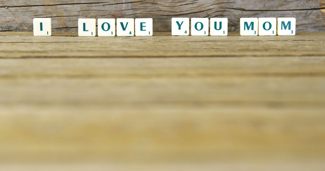 Scrabble Tiles Displaying 'I Love You Mom' on Wooden Table - Free Images, Stock Photos and Pictures on Pikwizard.com