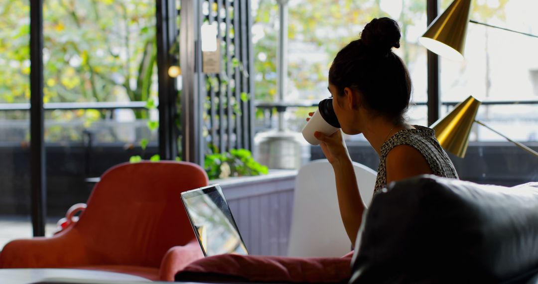 Woman Working Remotely from Cozy Coffee Shop with Laptop and Cup of Coffee - Free Images, Stock Photos and Pictures on Pikwizard.com