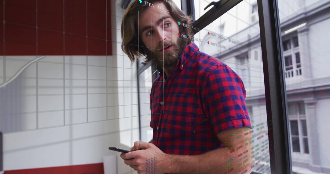 Young Businessman Analyzing Financial Graph with Smartphone at Office Window