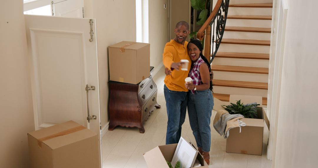 Cheerful Couple Arriving in New Home with Moving Boxes