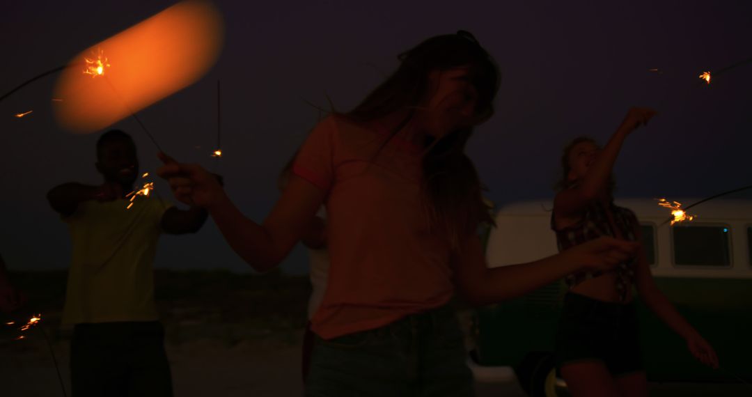 Joyful Friends Celebrating with Sparklers on Beach at Sunset - Free Images, Stock Photos and Pictures on Pikwizard.com