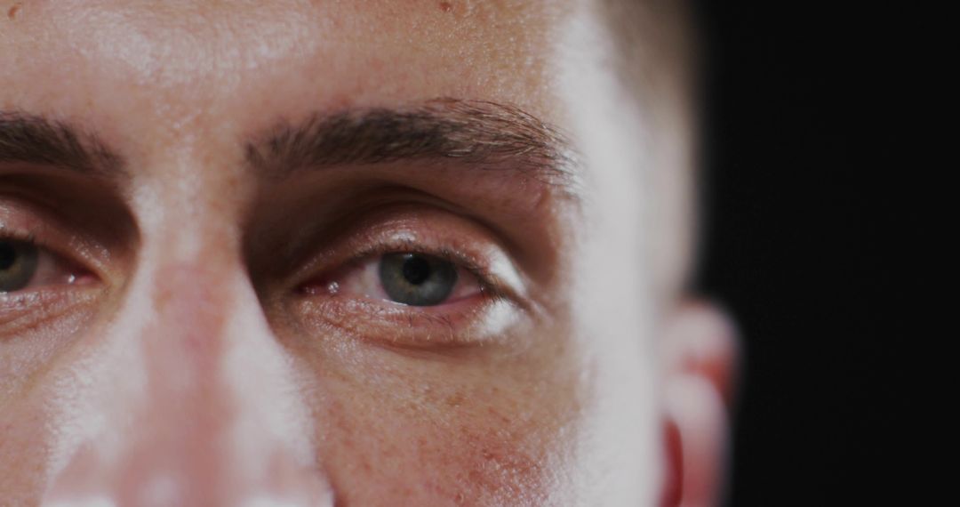 Close-up View of Man's Eyes and Skin Texture in Minimalist Setting