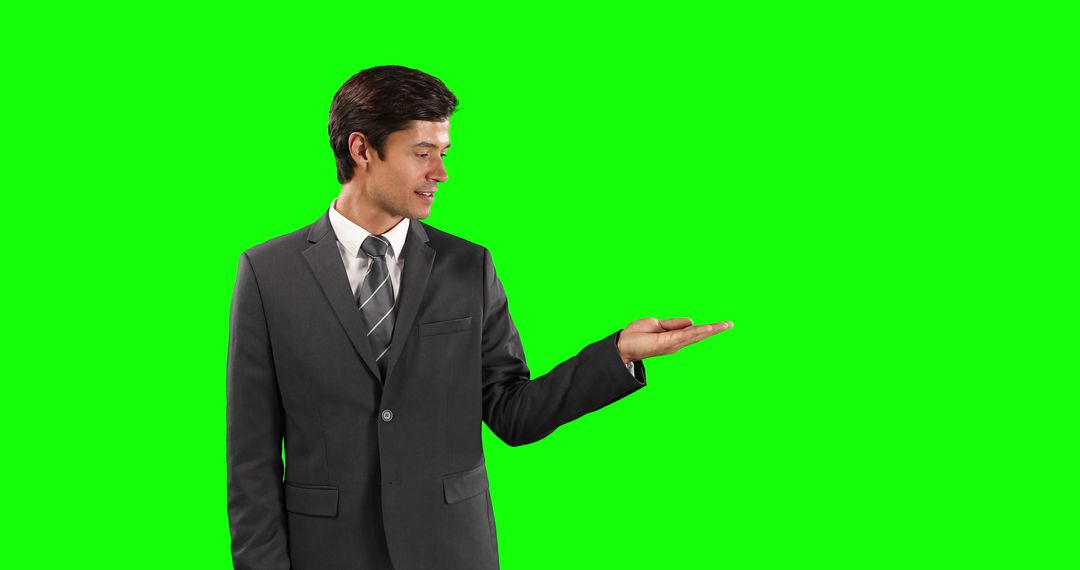 Confident Businessman Holding Invisible Object Against Green Screen - Free Images, Stock Photos and Pictures on Pikwizard.com