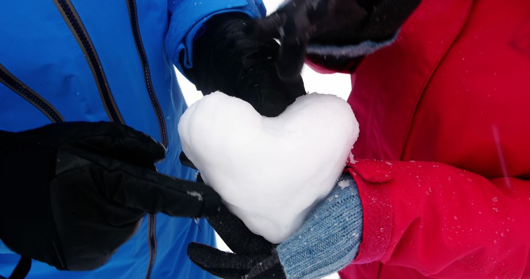 Couple Creating Heart Shape with Snow in Winter Wonderland - Free Images, Stock Photos and Pictures on Pikwizard.com