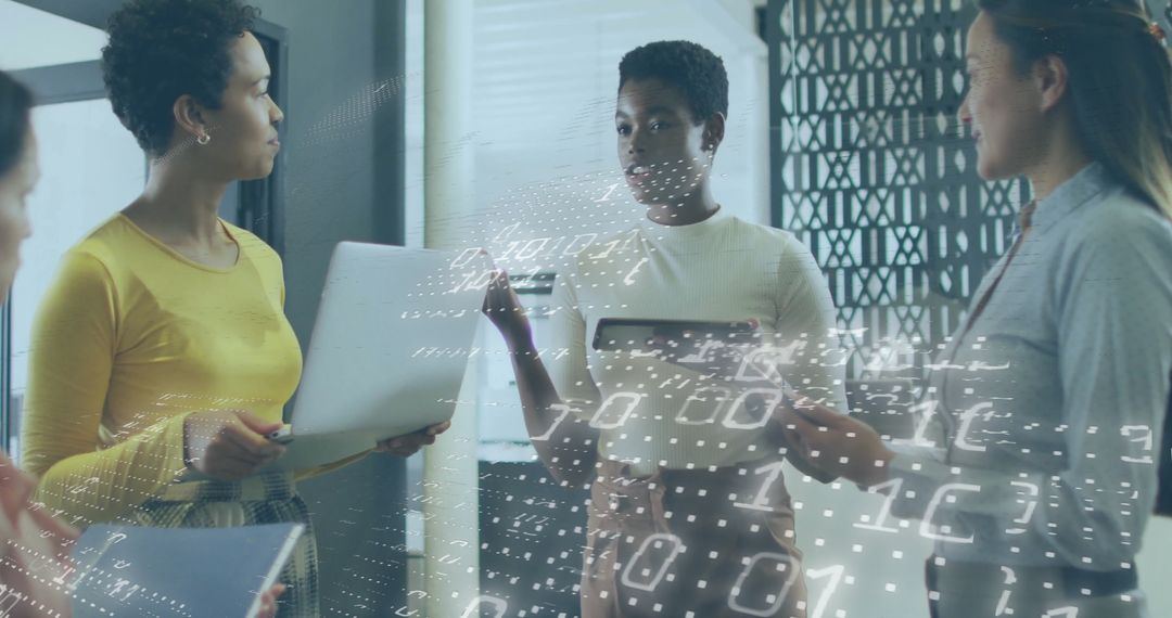 Women Collaborating on Tech Project with Digital Code Overlay