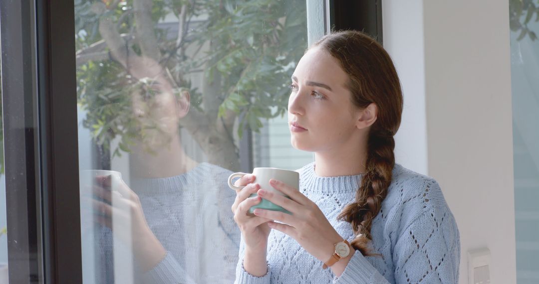 Reflective Woman Holding Mug by Window - Free Images, Stock Photos and Pictures on Pikwizard.com