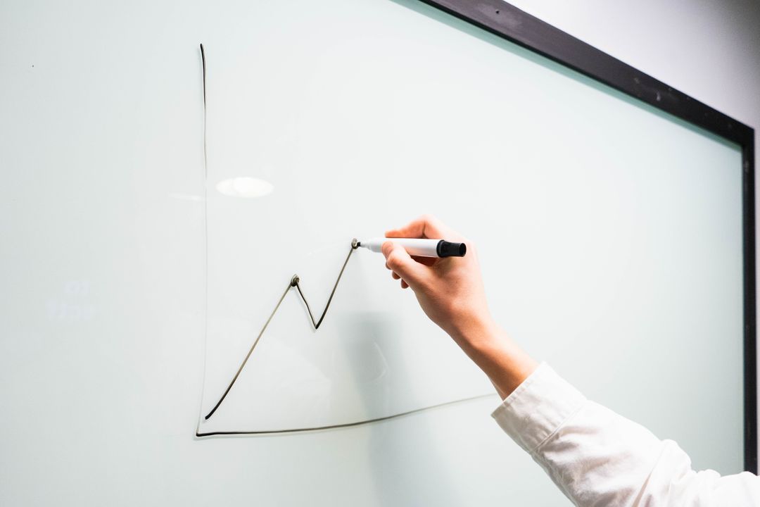 Person Drawing Graph on Whiteboard with Marker