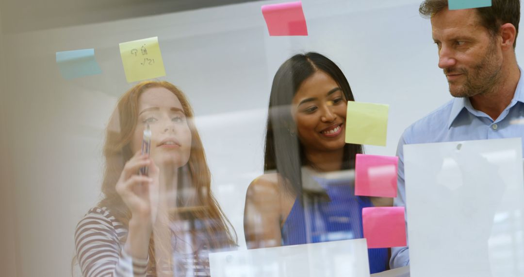 Diverse Team Collaborating with Sticky Notes on Glass Wall