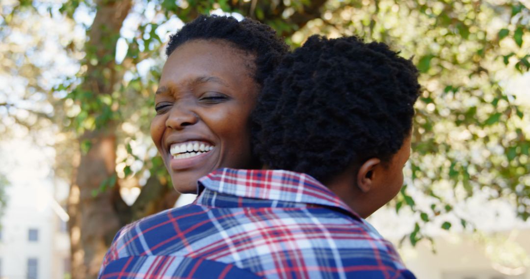 Joyful Twin Sisters Embracing Outdoors on a Sunny Day