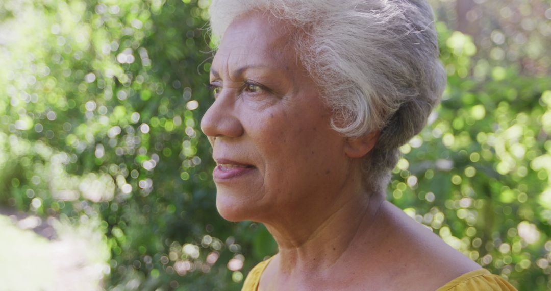 Thoughtful Senior Woman Enjoying Nature in Garden