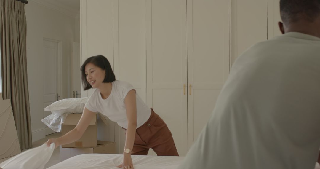 Couple Unpacking and Making Bed in New Home, Teamwork and Togetherness