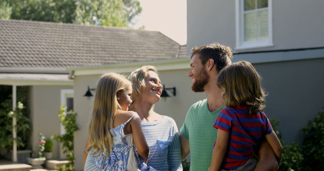 Happy Family Embracing in Front of Home on Sunny Day - Free Images, Stock Photos and Pictures on Pikwizard.com