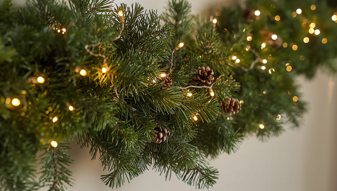 Evergreen Garland on Mantel with Warm LED String Lights, Pine Cones and Bokeh