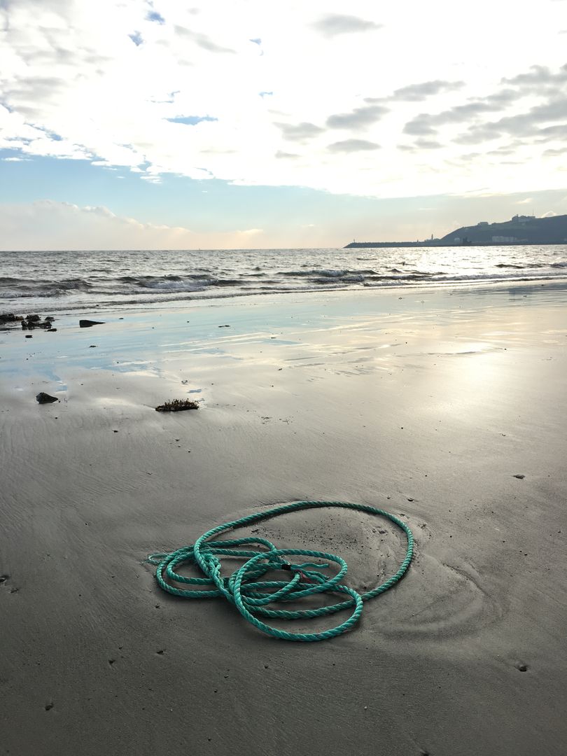 Green Rope on Sand at Calm Beach - Free Images, Stock Photos and Pictures on Pikwizard.com