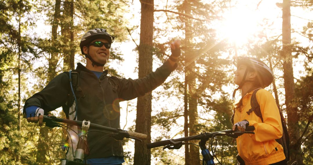 Mountain Bikers Giving High Five in Sunlit Forest - Free Images, Stock Photos and Pictures on Pikwizard.com