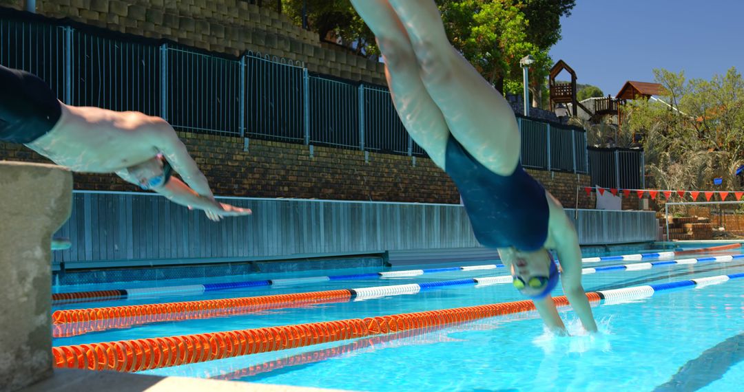 Swimmers diving into outdoor pool during training session - Free Images, Stock Photos and Pictures on Pikwizard.com