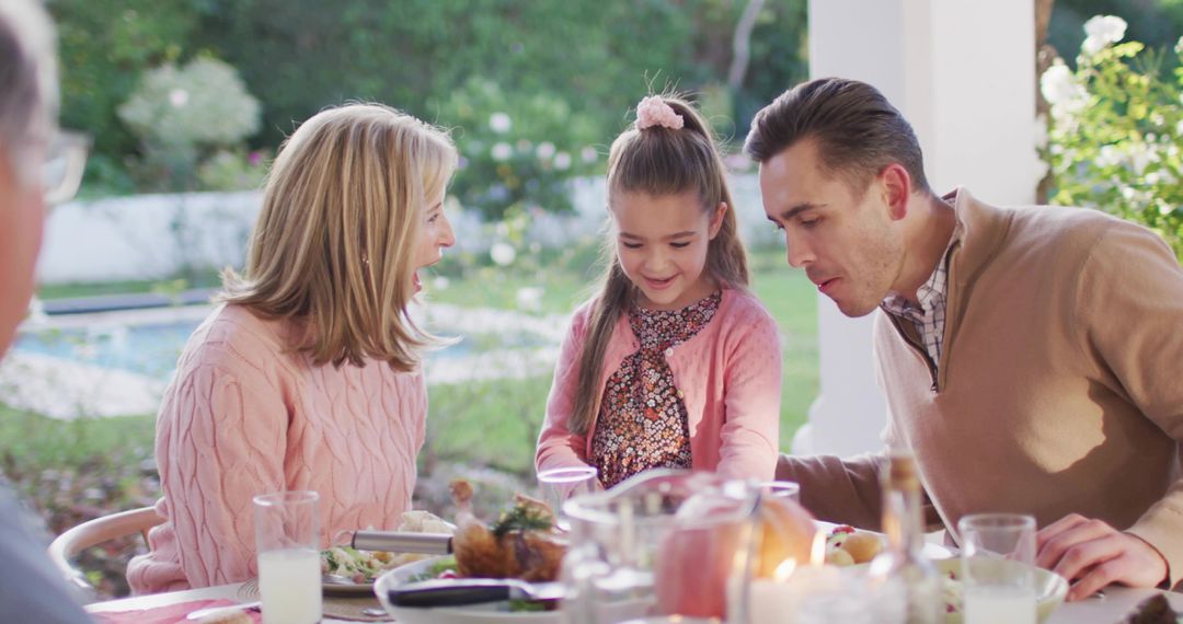 Young Girl Serving Dessert While Parents React During Backyard Alfresco Meal