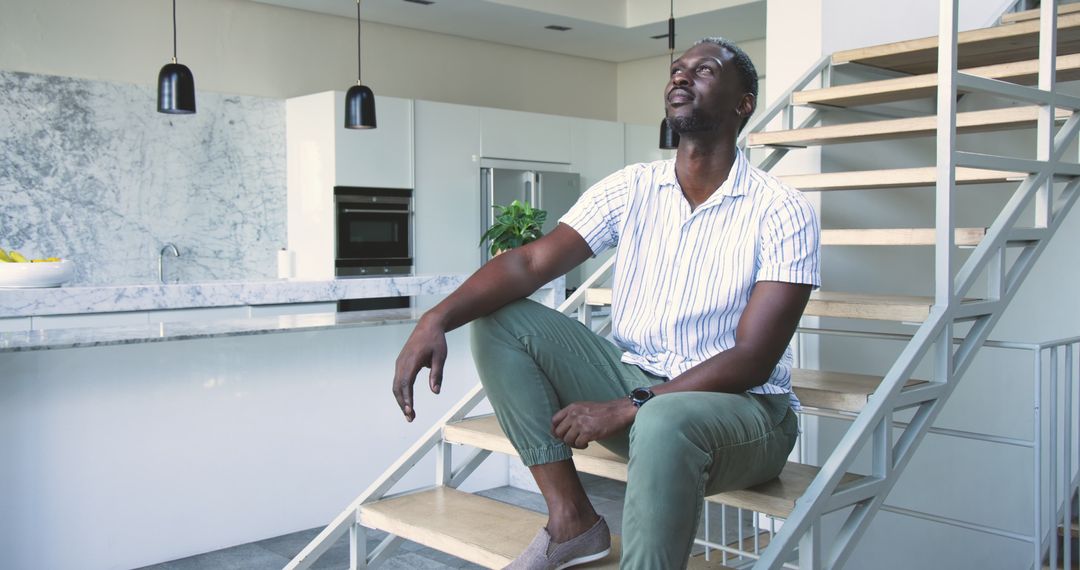 Man Relaxing on Stylish Staircase in Modern Minimalist Kitchen