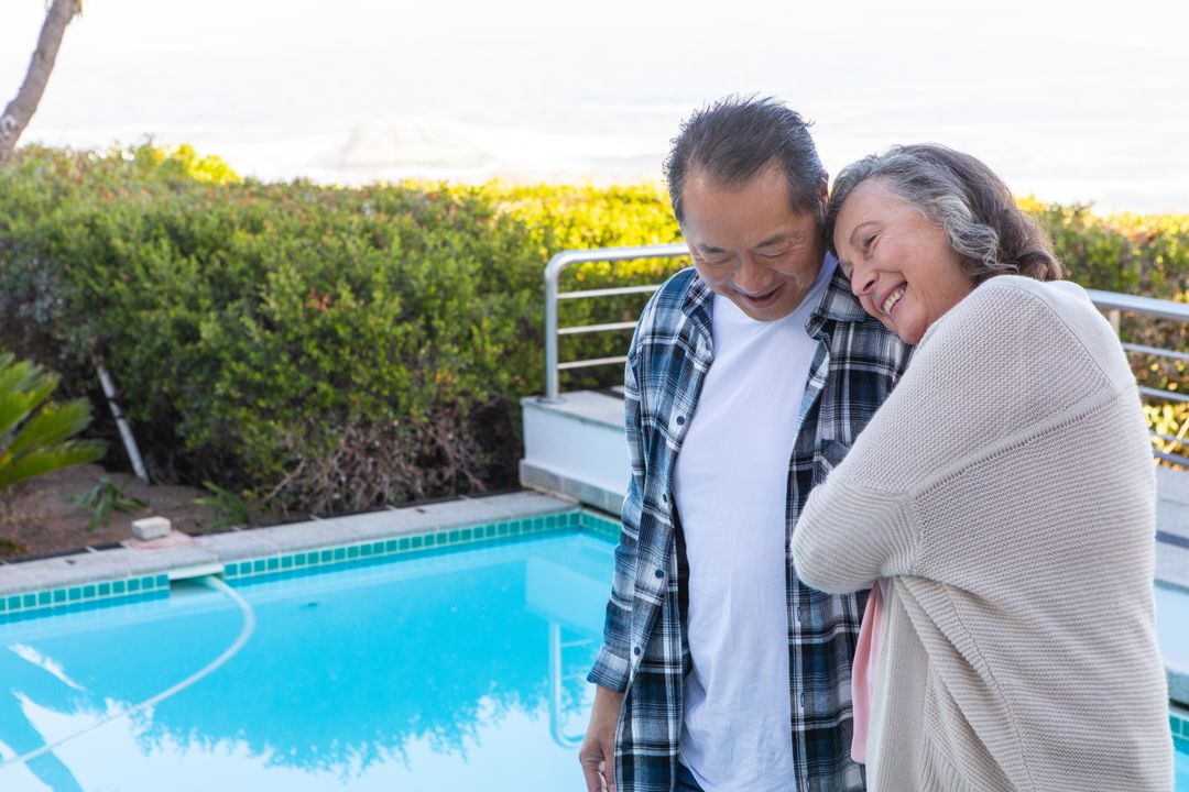 Senior Couple Embracing by Pool in Tranquil Outdoor Space