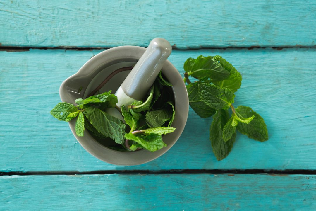 Mint leaves with mortar and pestle on wooden table - Free Images, Stock Photos and Pictures on Pikwizard.com
