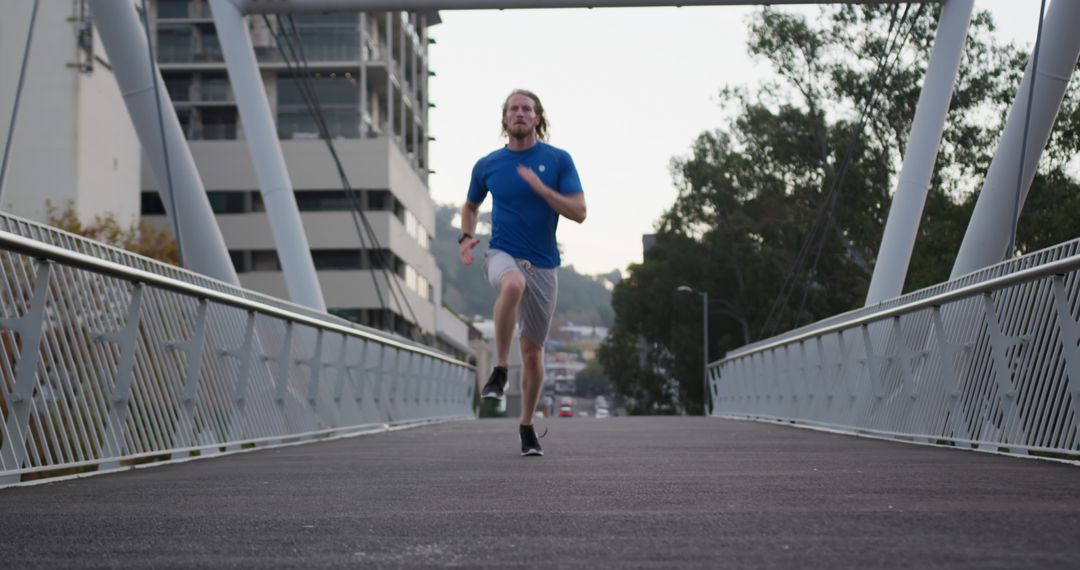 Young Man Running on Urban Bridge for Exercise - Free Images, Stock Photos and Pictures on Pikwizard.com