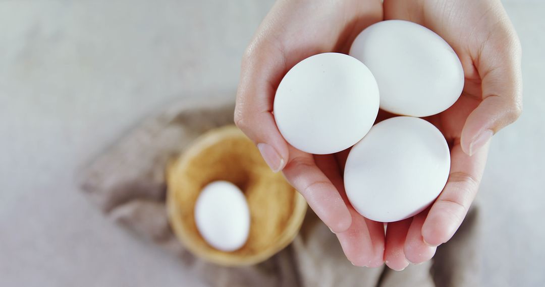 Hands holding three white eggs with one egg in background - Free Images, Stock Photos and Pictures on Pikwizard.com