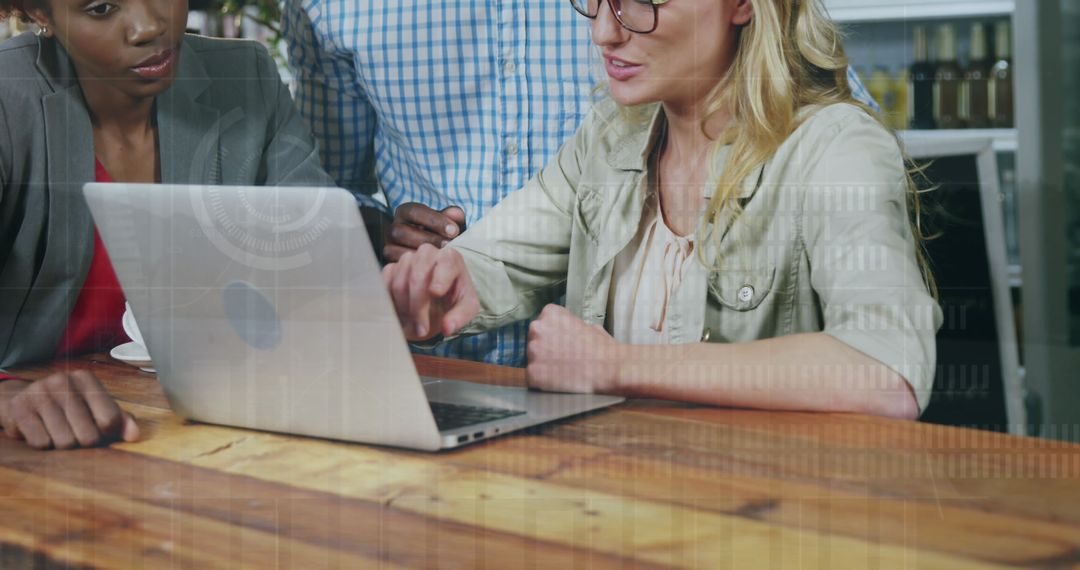 Collaborative Team Analyzing Data on Laptop with Overlay Graphics