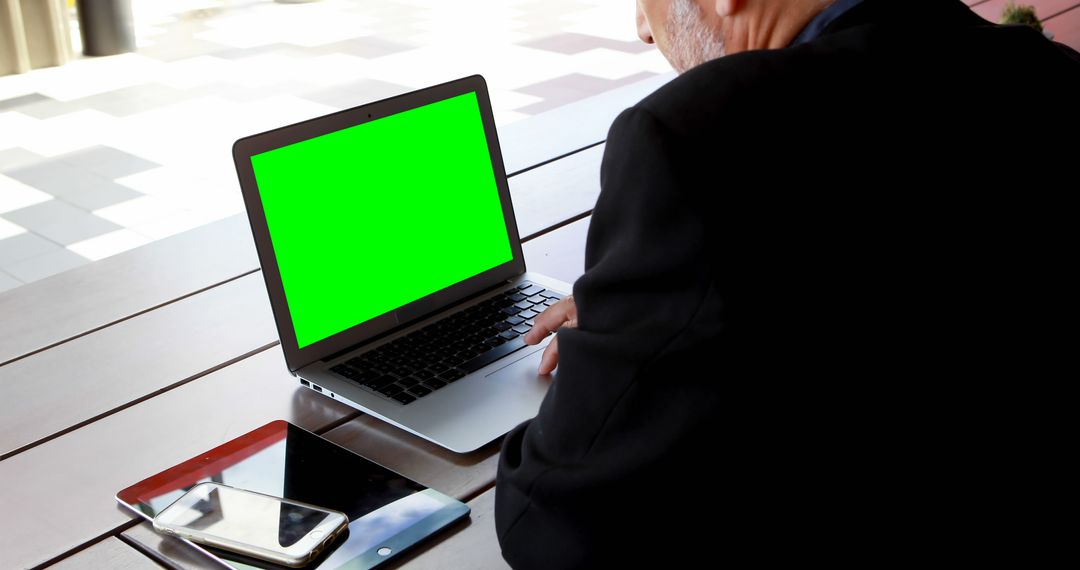 Businessman Working on Laptop with Green Screen in Outdoor Office - Free Images, Stock Photos and Pictures on Pikwizard.com