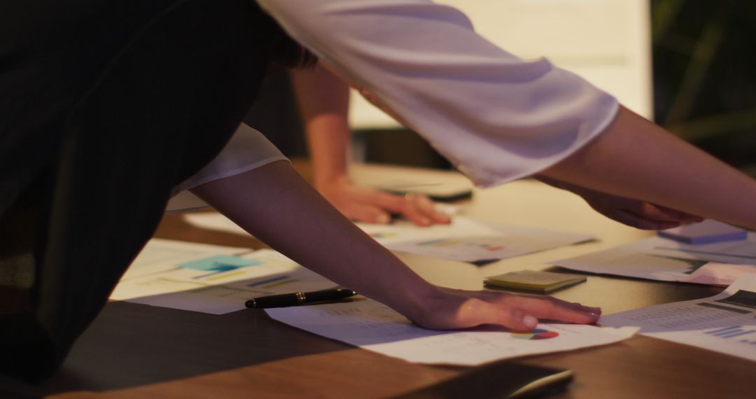 Collaborative Business Team Analyzing Financial Reports at Night