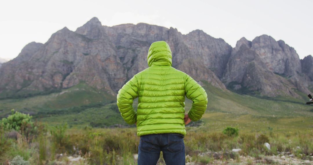 Hiker in Green Jacket Facing Mountain Range - Free Images, Stock Photos and Pictures on Pikwizard.com