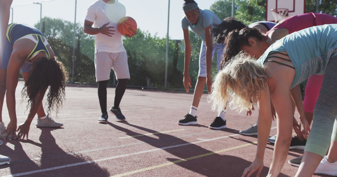 Group of Athletes Stretching on Outdoor Basketball Court - Free Images, Stock Photos and Pictures on Pikwizard.com