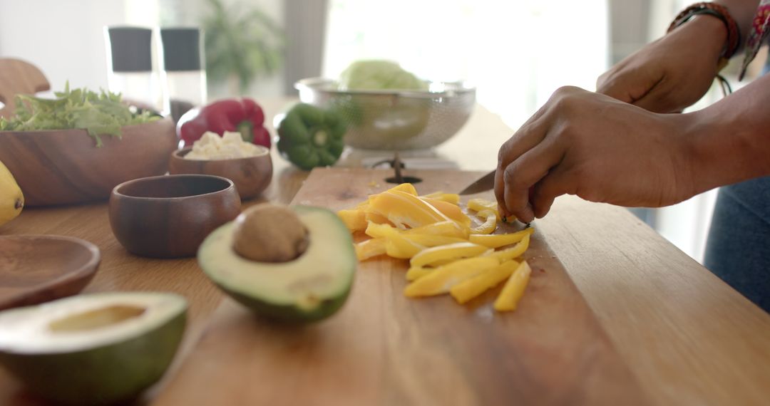 Slicing Fresh Mango with Avocado and Vegetables in Kitchen Setting