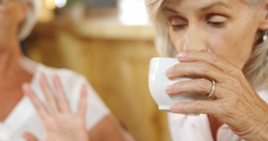 Senior Woman Enjoying Drink While Gesturing in Coffee Shop - Free Images, Stock Photos and Pictures on Pikwizard.com