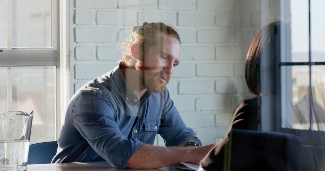 Man Engaging in Thoughtful Discussion at Office Meeting Table