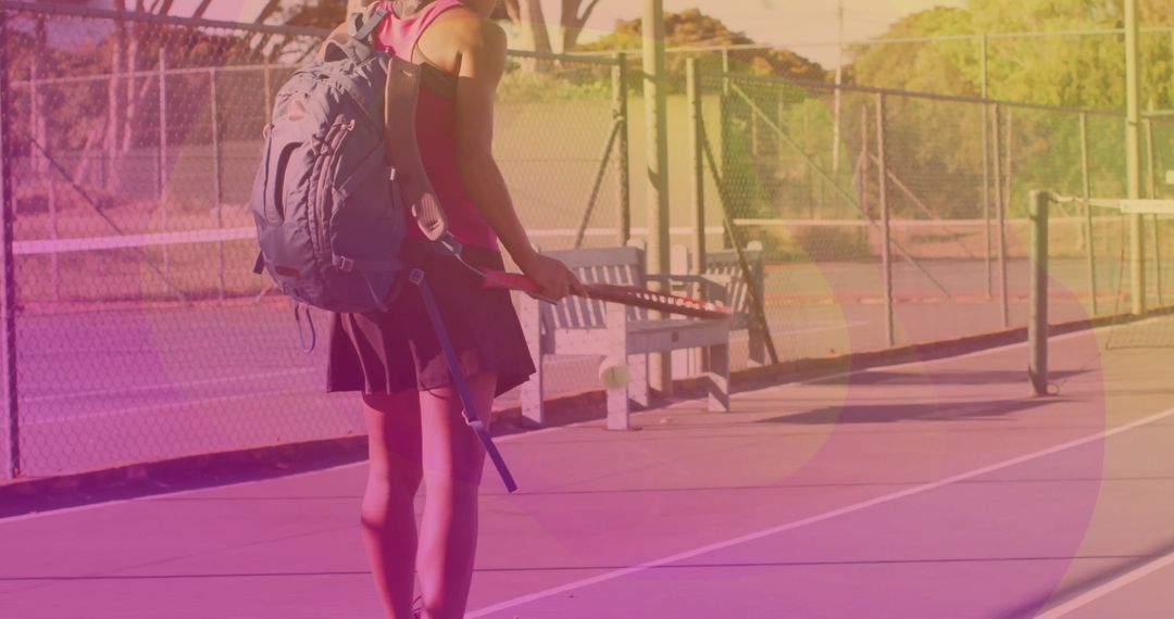 Tennis Player Walking with Racket and Backpack at Tennis Court