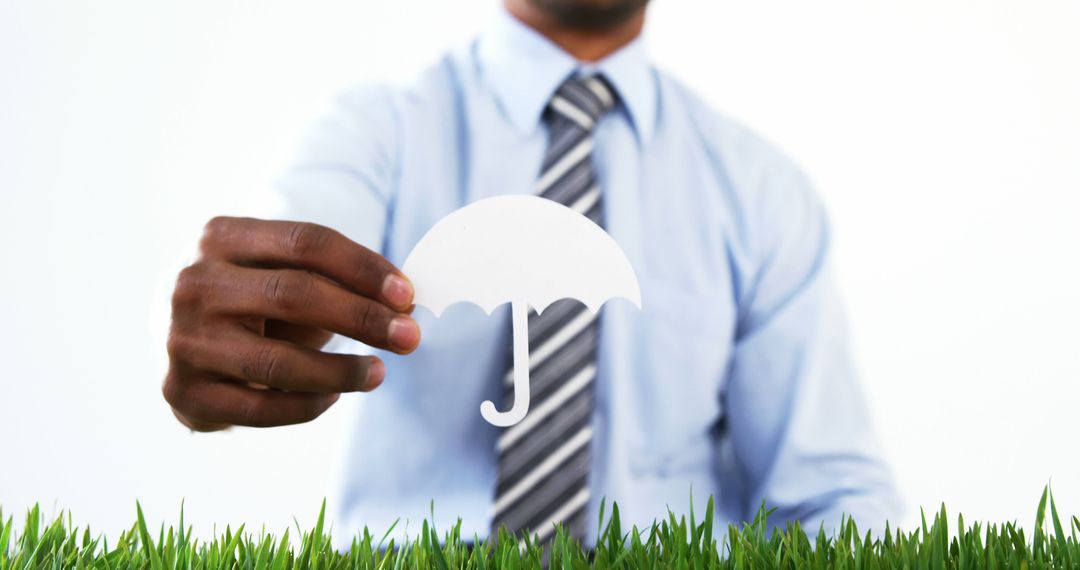 Man Holding Paper Umbrella Symbol over Grass - Free Images, Stock Photos and Pictures on Pikwizard.com