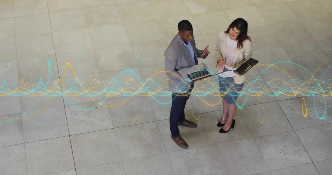 Colleagues Analyzing Data with Digital Overlay in Corporate Lobby