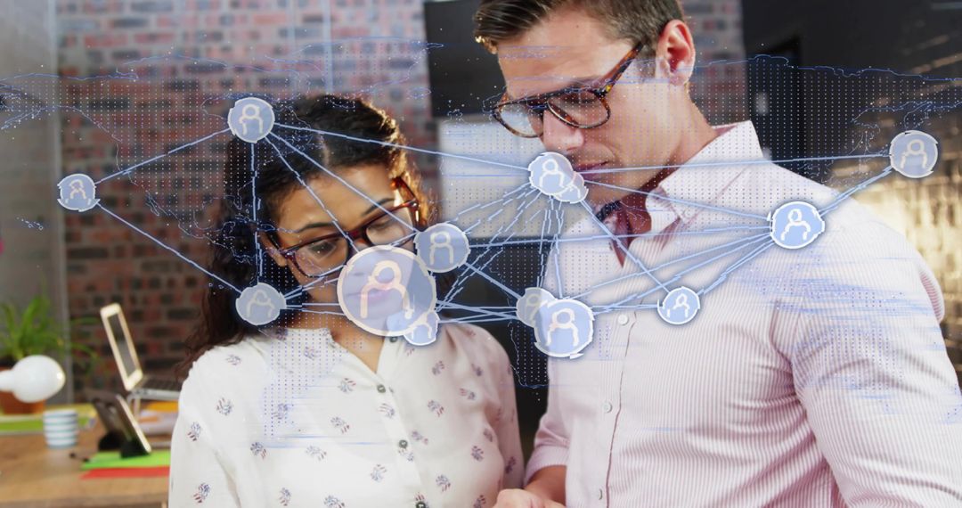Coworkers analyzing social network overlay on tablet in modern brick office