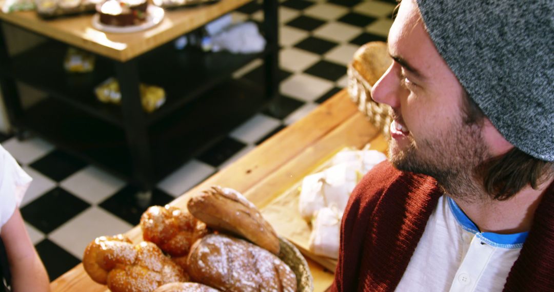 Smiling Man in a Bakery Near Freshly Baked Bread - Free Images, Stock Photos and Pictures on Pikwizard.com