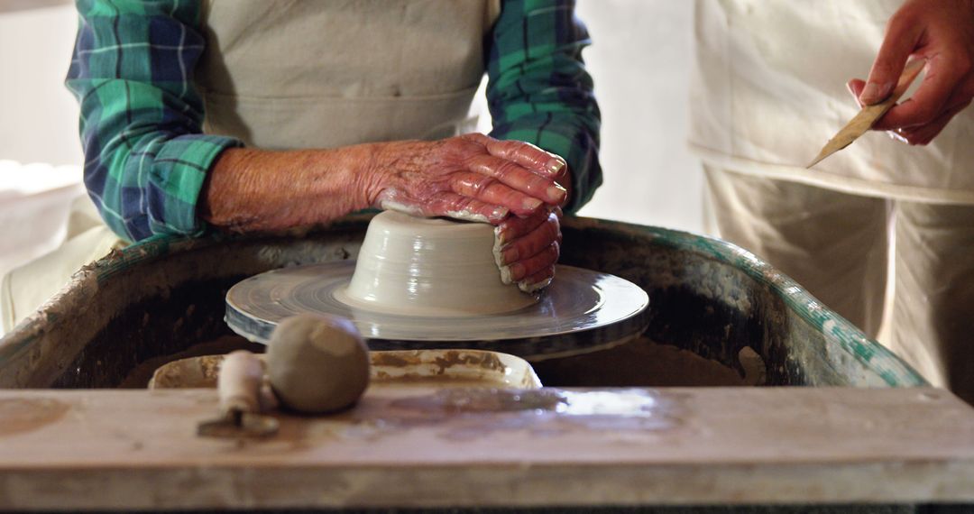 Senior Pottery Maker with Student Using Pottery Wheel - Free Images, Stock Photos and Pictures on Pikwizard.com