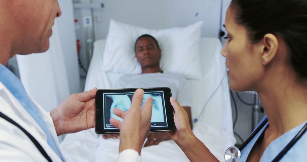 Doctors Discussing Patient X-ray Using Tablet in Hospital Room - Free Images, Stock Photos and Pictures on Pikwizard.com