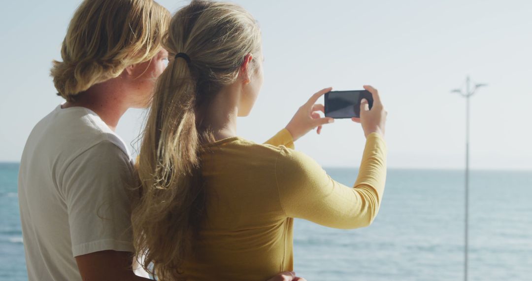 Couple Taking Photo of Scenic Ocean View During Sunny Day - Free Images, Stock Photos and Pictures on Pikwizard.com