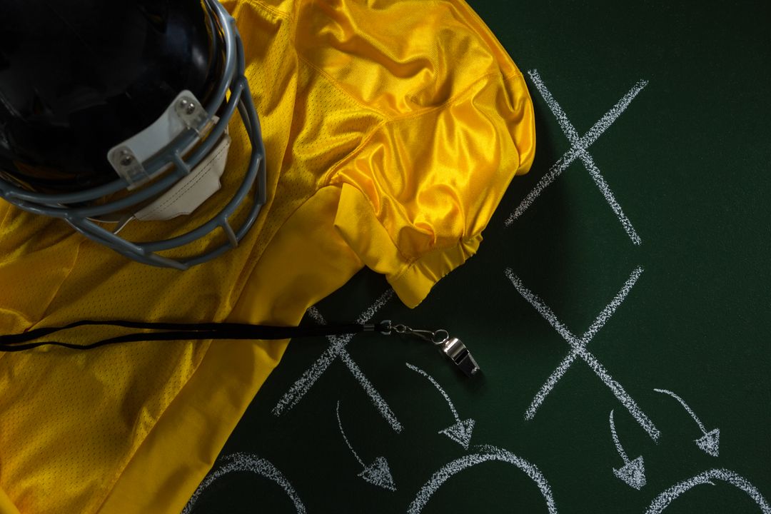 Football gear and strategy plan displayed on a green board. - Free Images, Stock Photos and Pictures on Pikwizard.com