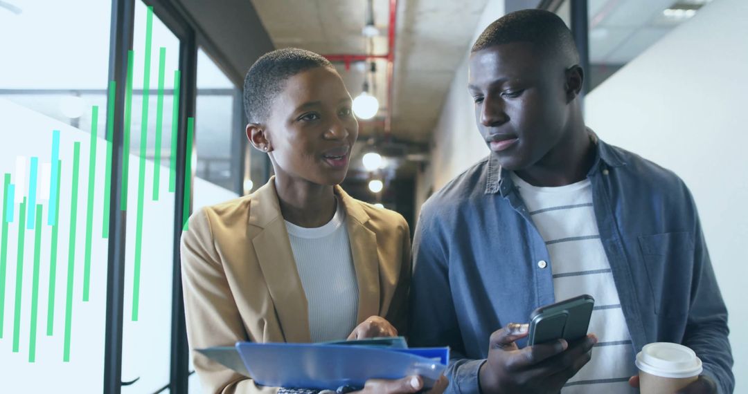 Colleagues Analyzing Data in Modern Office Corridor