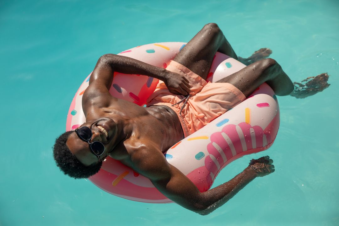 Man Relaxing on Pool Float with Sunglasses on Sunny Day