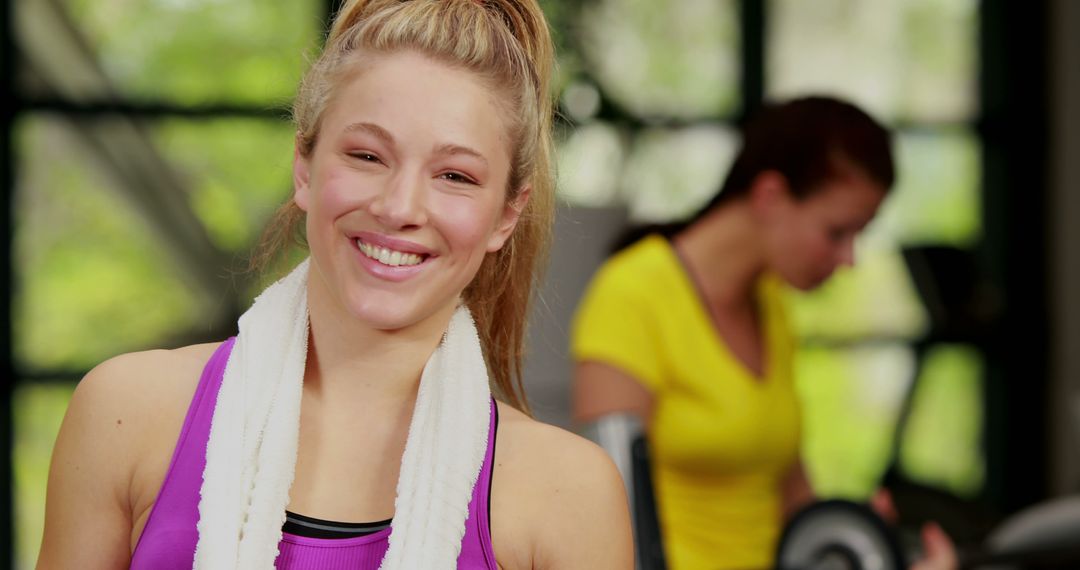 Smiling Woman at Gym with Workout Towel around Neck - Free Images, Stock Photos and Pictures on Pikwizard.com