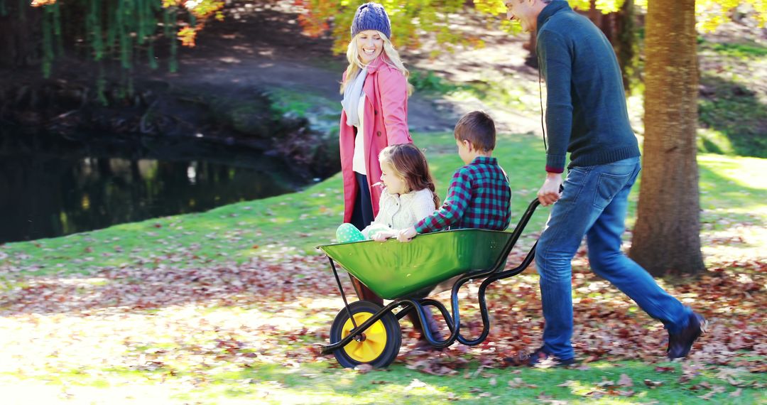 Family Enjoying Outdoor Autumn Day with Children in Wheelbarrow - Free Images, Stock Photos and Pictures on Pikwizard.com